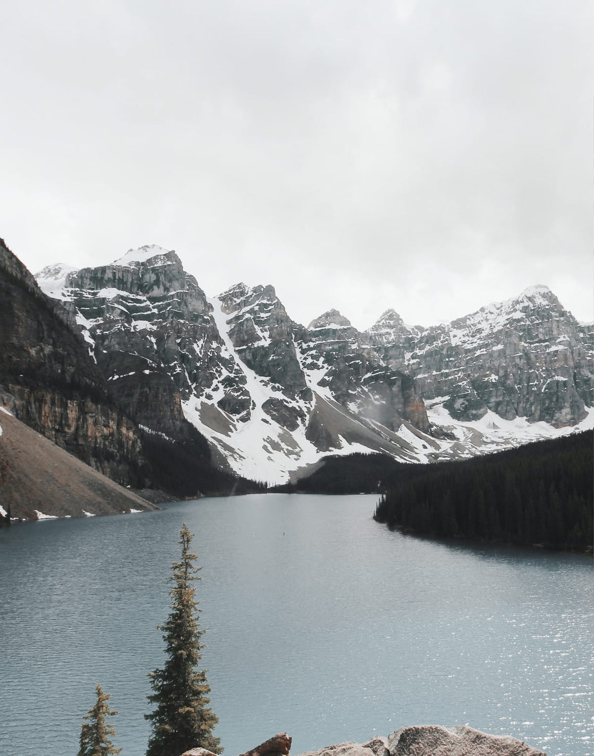 Mountain lake with snow-streaked peaks and a conifer shoreline