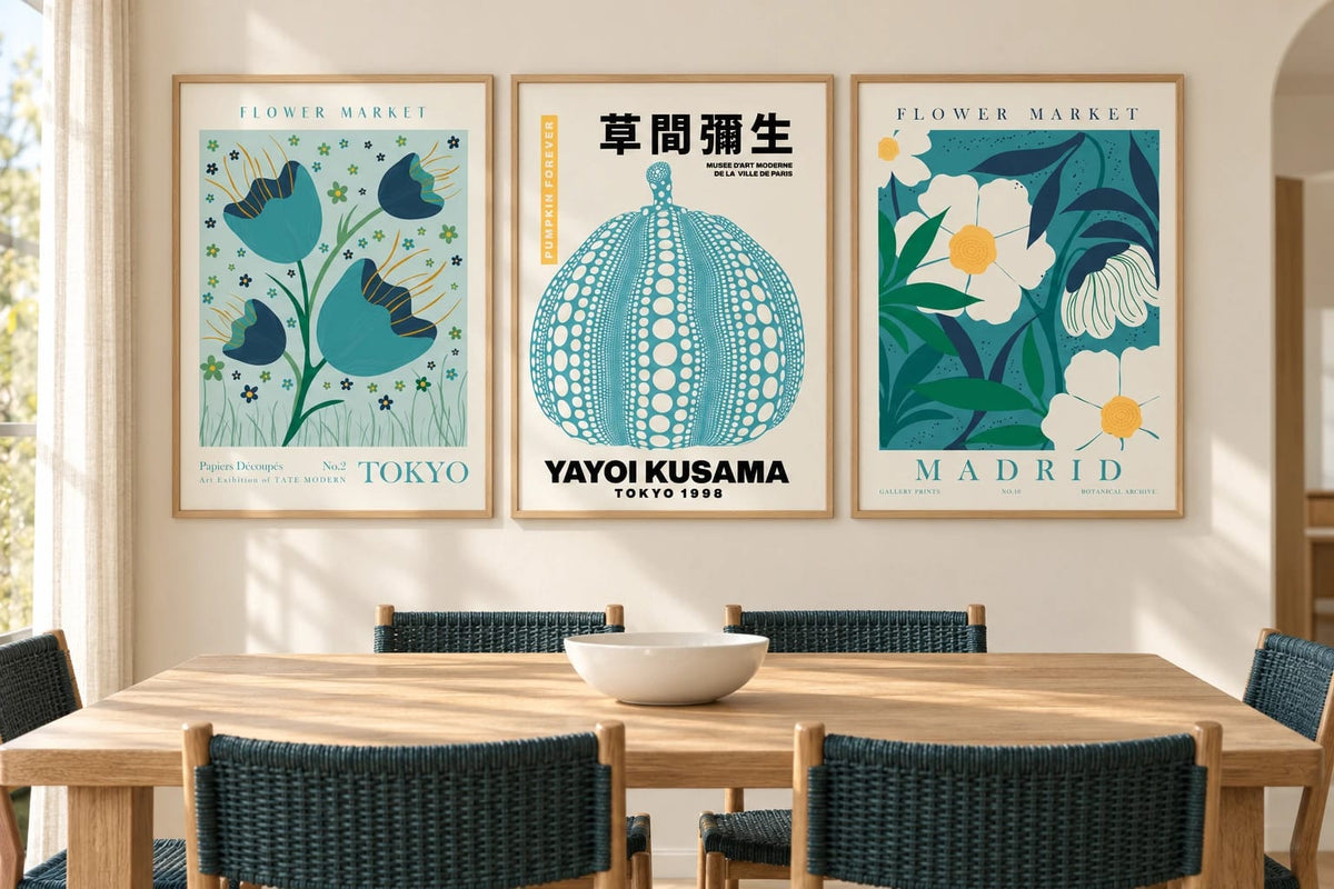 Botanical triptych above a dining table with turquoise chairs.