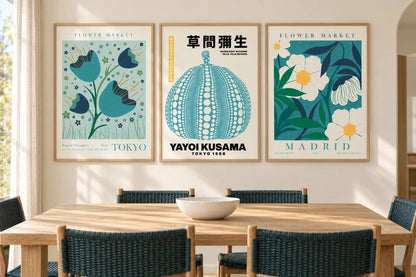 Botanical triptych above a dining table with turquoise chairs.