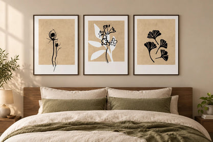 Three neutral leaf prints above a bed with olive textiles.