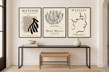 Leaf, tree, and profile prints above a black console.