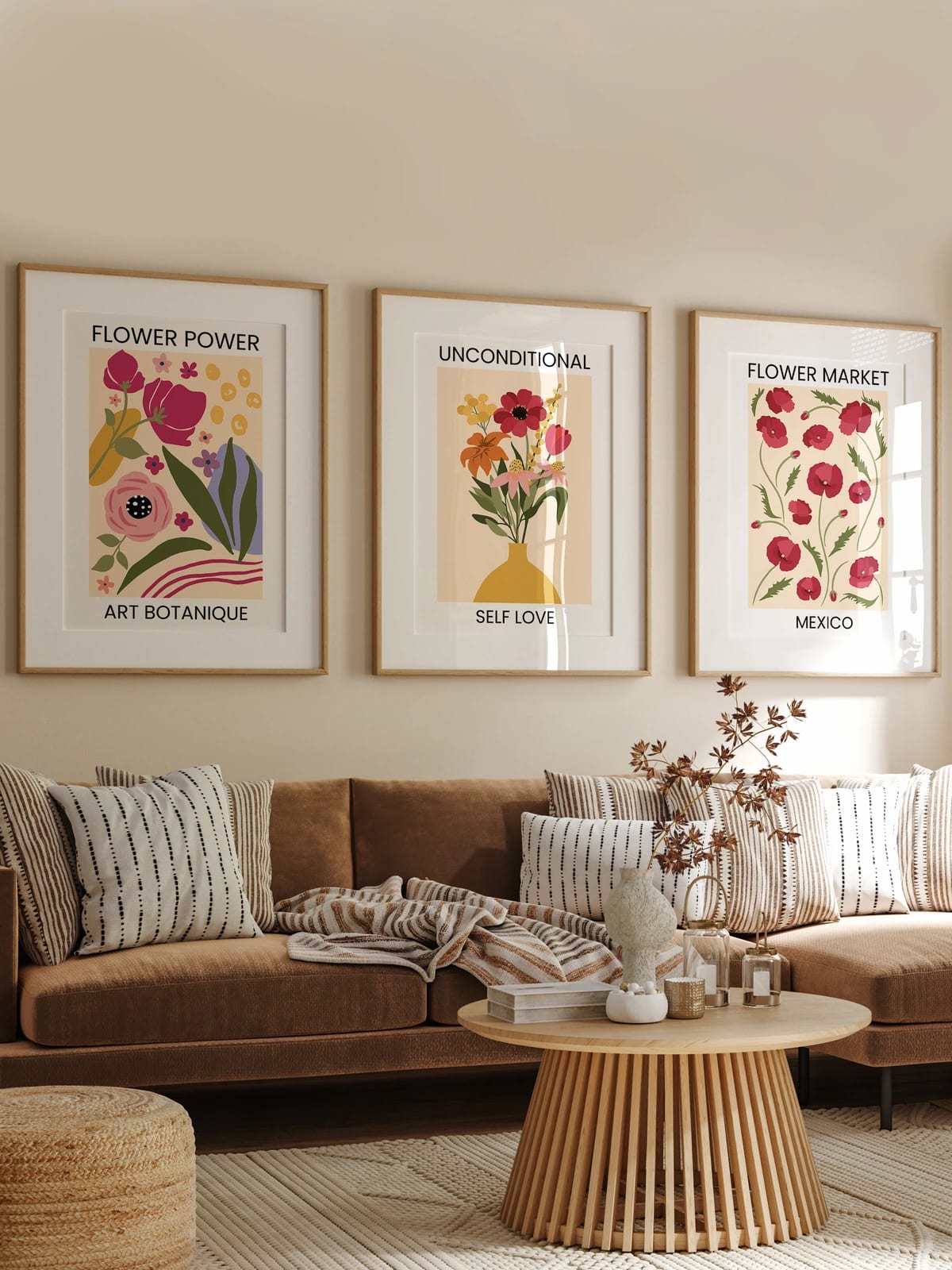 Three floral prints hang above a brown sofa against a beige wall.