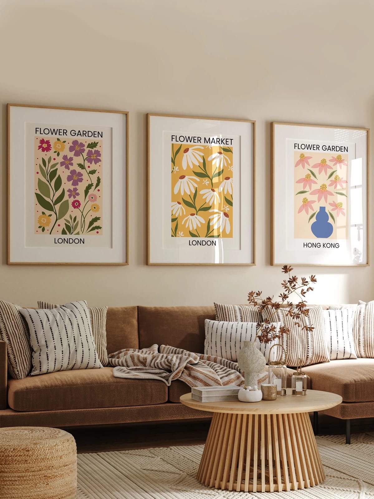 Three floral prints hang above a brown sofa on a beige wall.