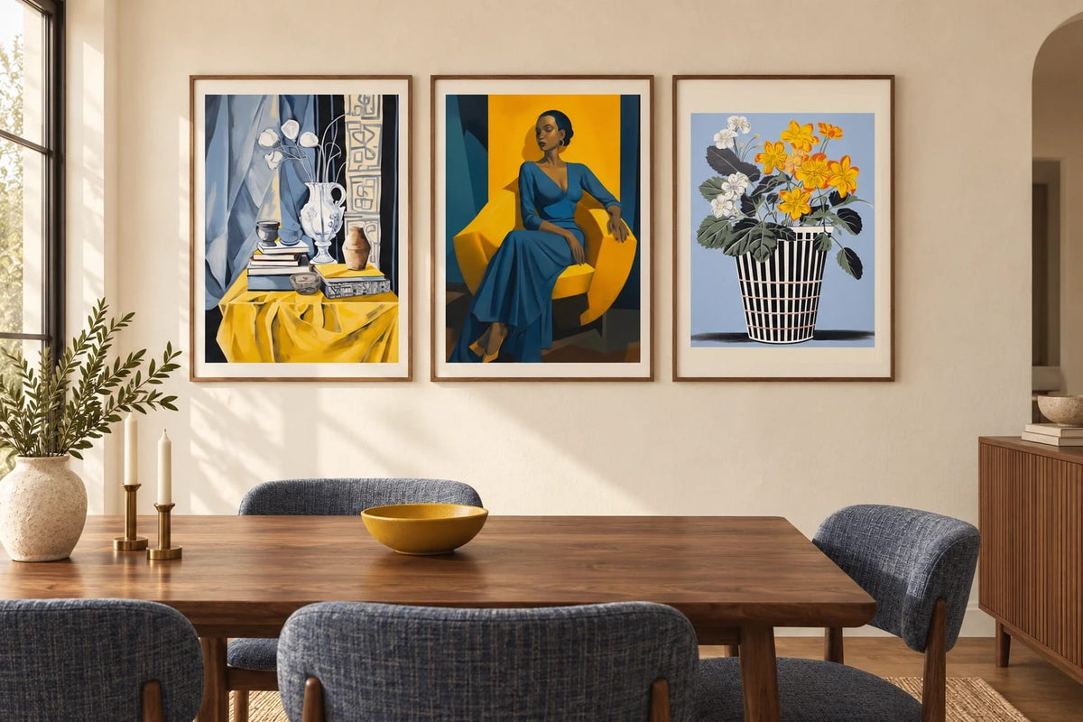 Still-life, portrait, and flower prints are displayed in a bright dining room with a wooden table.