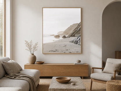 Neutral coastal cliff print above a pale-oak console in a warm white living room