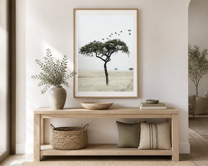 Lone tree and birds print above a pale-oak console in a warm ivory entryway