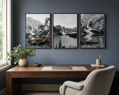 Mountain lake and boats triptych above a walnut desk on a blue-gray wall