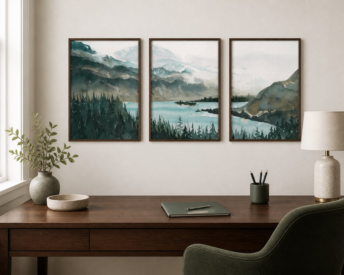 Deep green mountain-lake triptych above a dark-walnut desk in a warm white office
