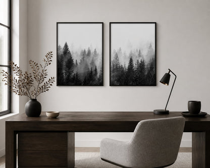 Monochrome misty-forest pair above a dark-walnut desk in a minimal office