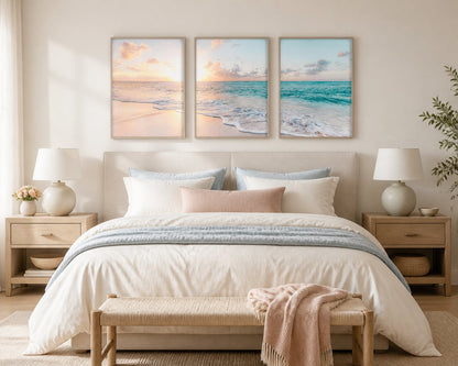 Pastel coastal triptych above an ivory bed with peach and blue-gray textiles