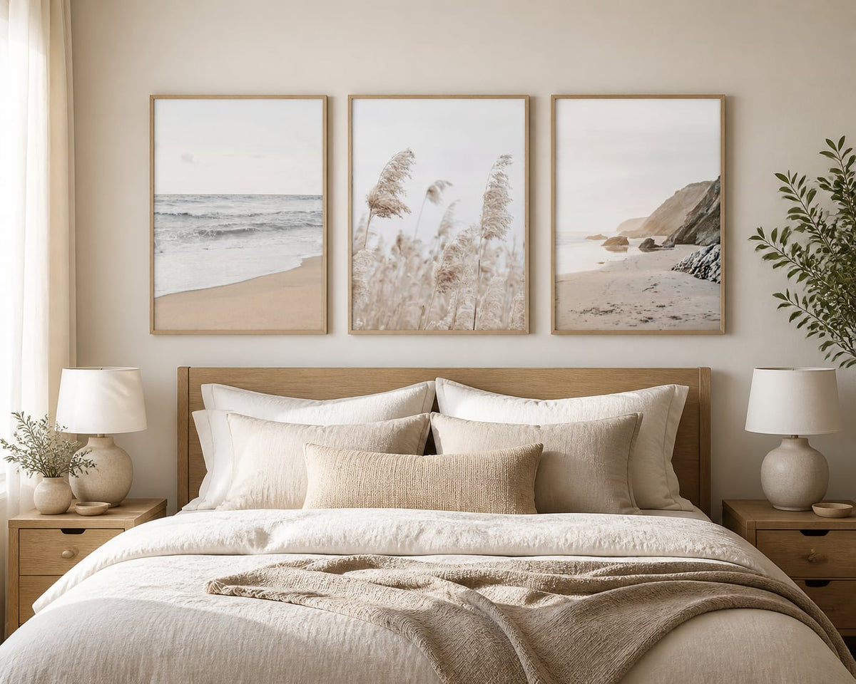 Neutral coastal triptych above an ivory bed with pale oak and sand textiles