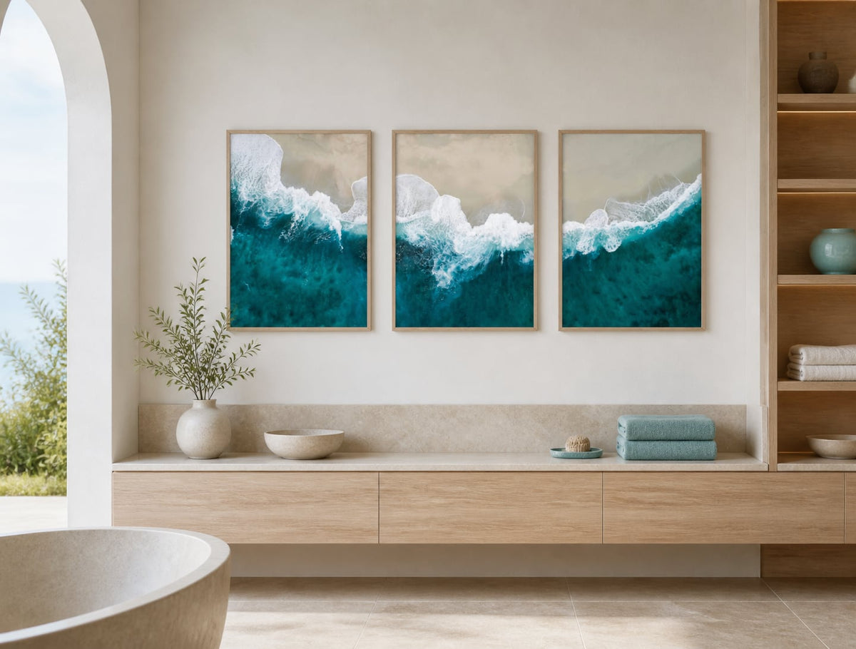Turquoise shoreline triptych on a dry wall in a pale-oak spa-like bathroom