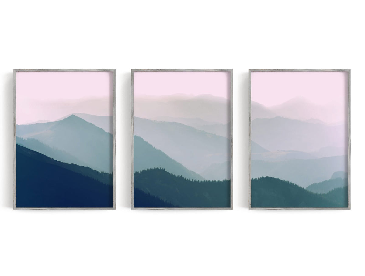 Three layered blue-green mountain panels beneath a pale pink horizon