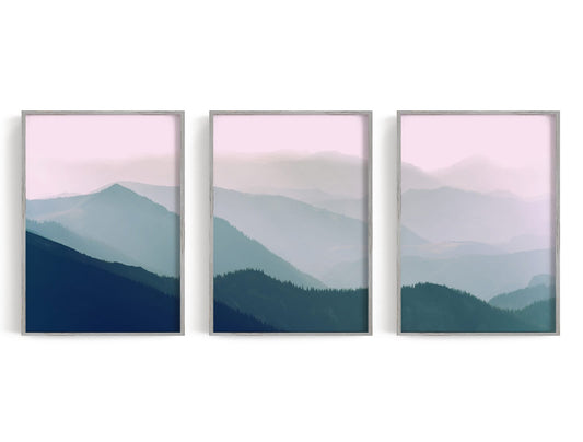 Three layered blue-green mountain panels beneath a pale pink horizon