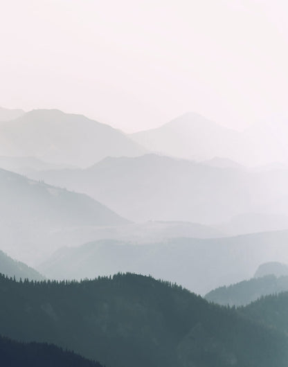 Dark navy foreground ridge with softer mountains behind