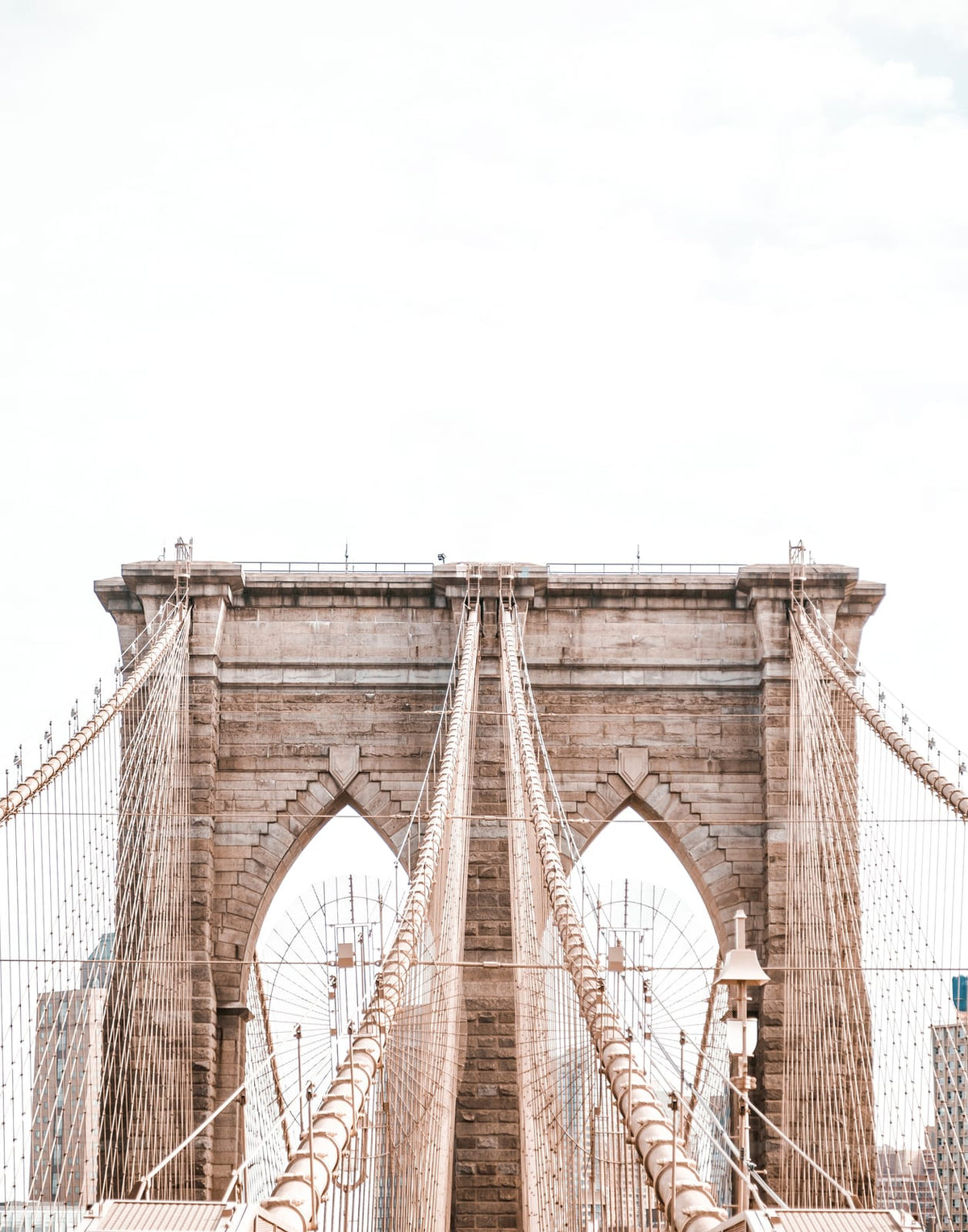 Black-and-white view of a suspension bridge and city structures