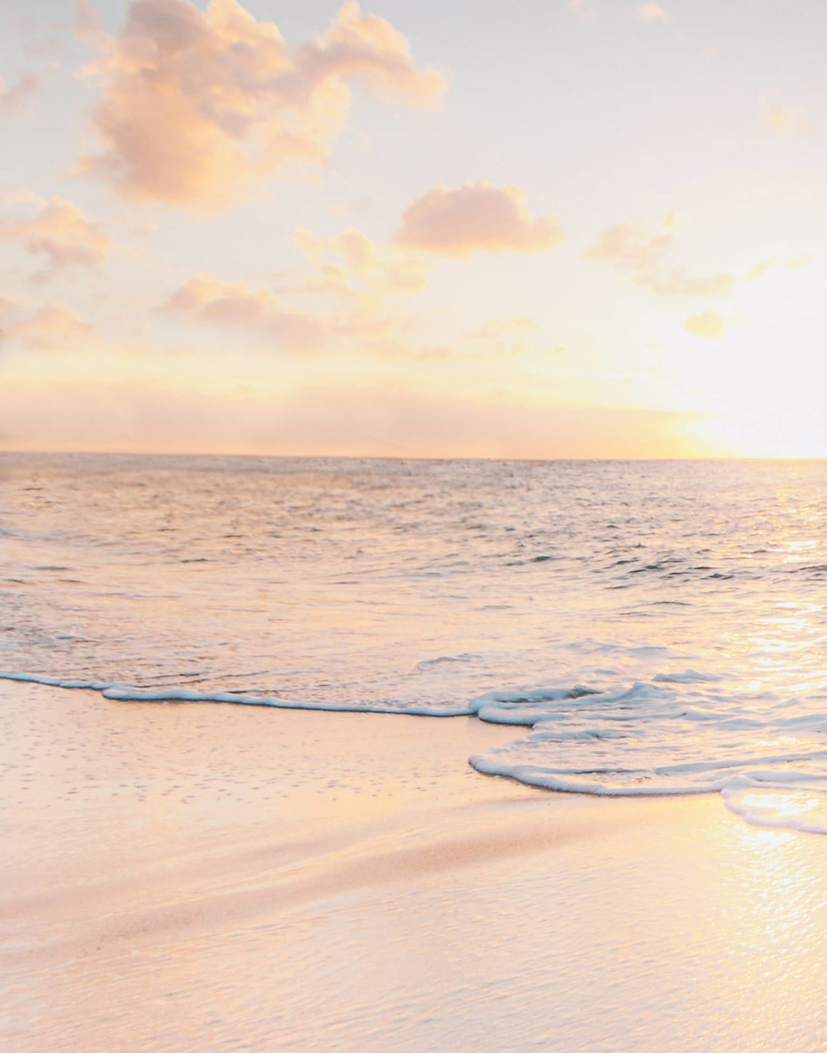 Pale coastal sky above calm blue and turquoise water