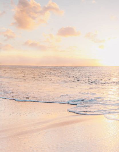 Pale coastal sky above calm blue and turquoise water
