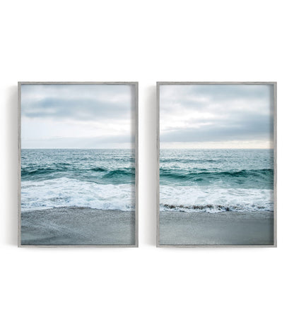 Two blue-gray shoreline prints with pale surf and a quiet coastal horizon