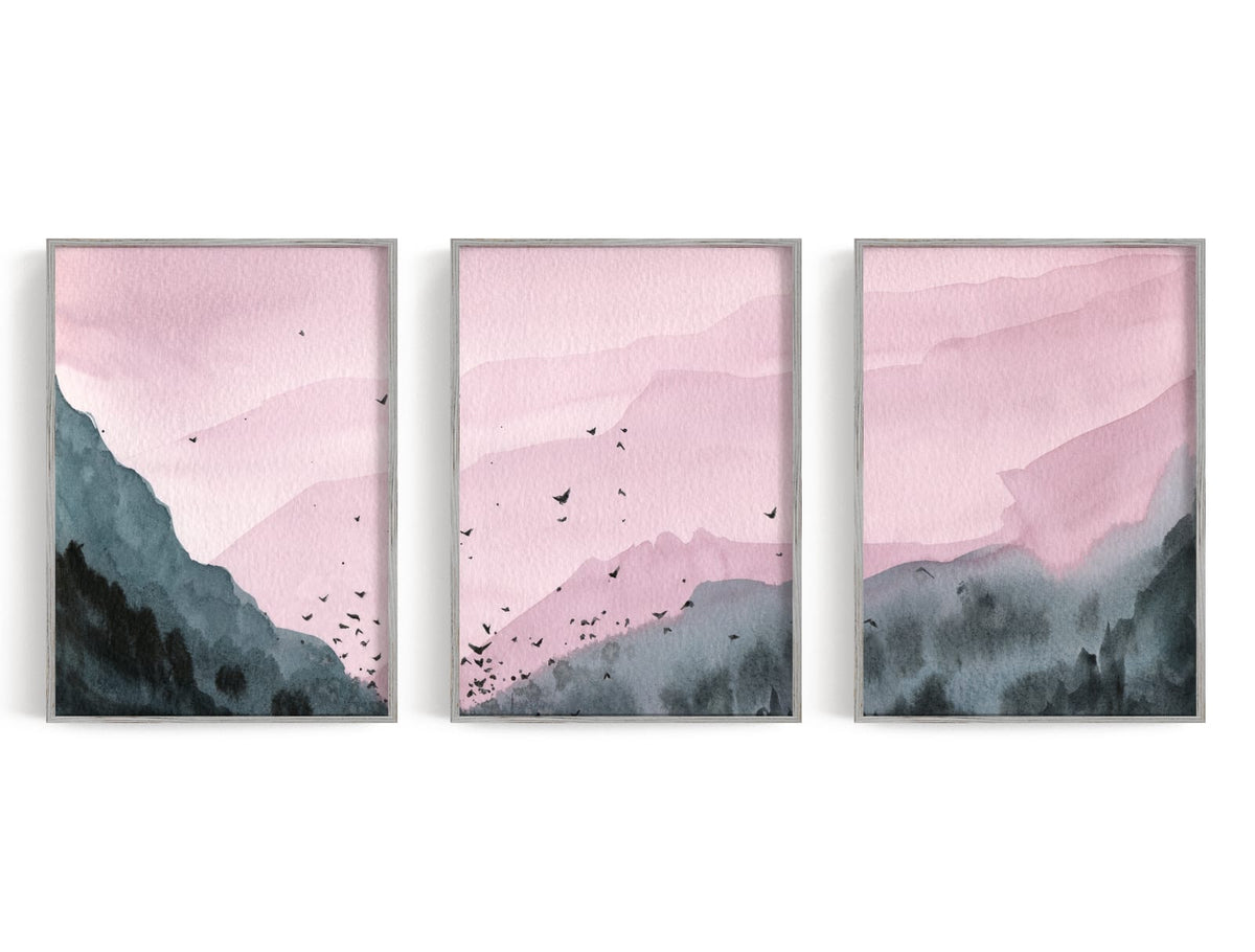 Three layered mountains in dusty rose and charcoal with birds crossing the center