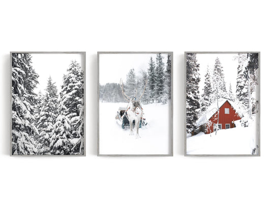 Snowy forest trio with a small red cabin and reindeer-like central scene