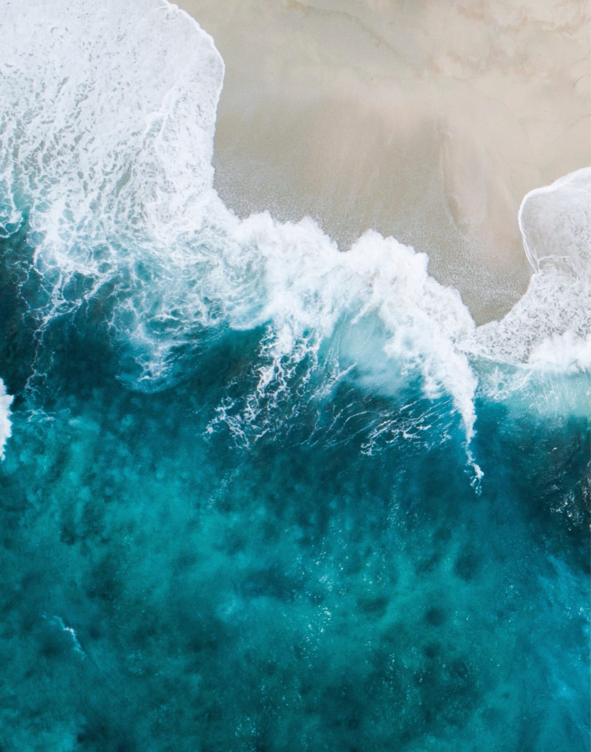 Overhead shoreline with pale sand and turquoise water
