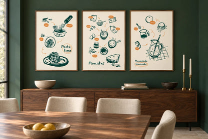 Three food prints hang above a wood cabinet on a dark green wall.