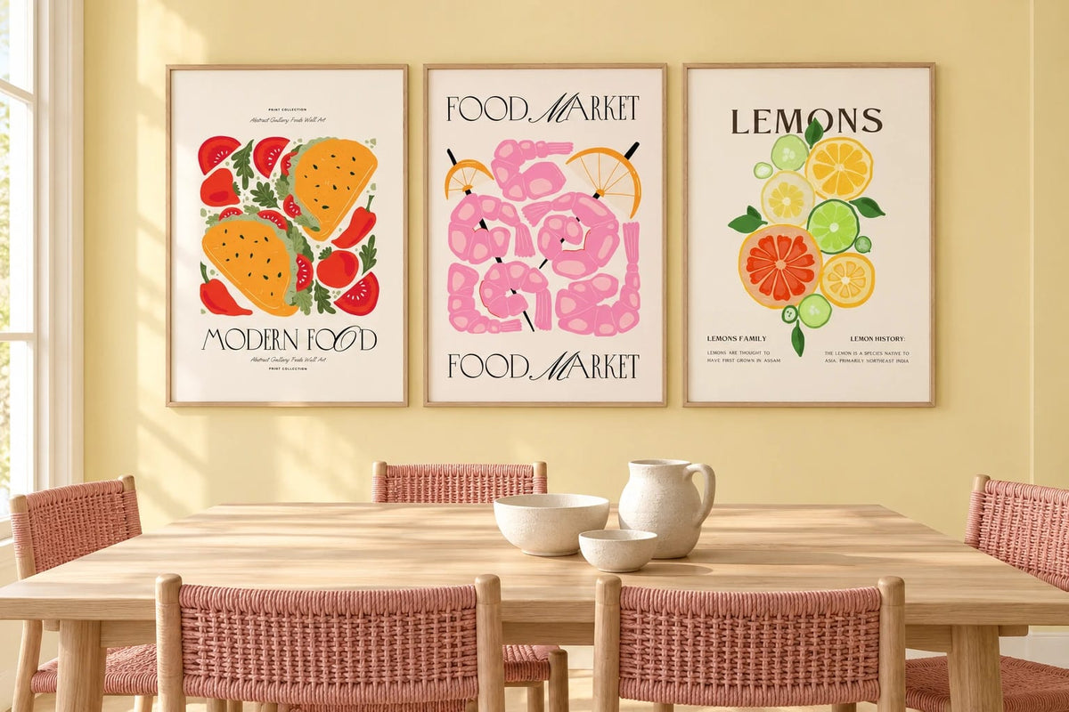 Three food prints hang above a wooden table in a light dining room.