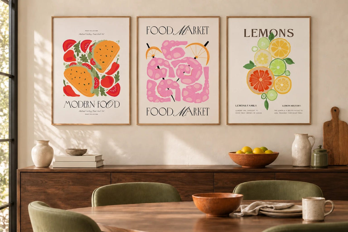 Tomatoes, pink shapes, and citrus appear above a wood sideboard in a bright dining room.