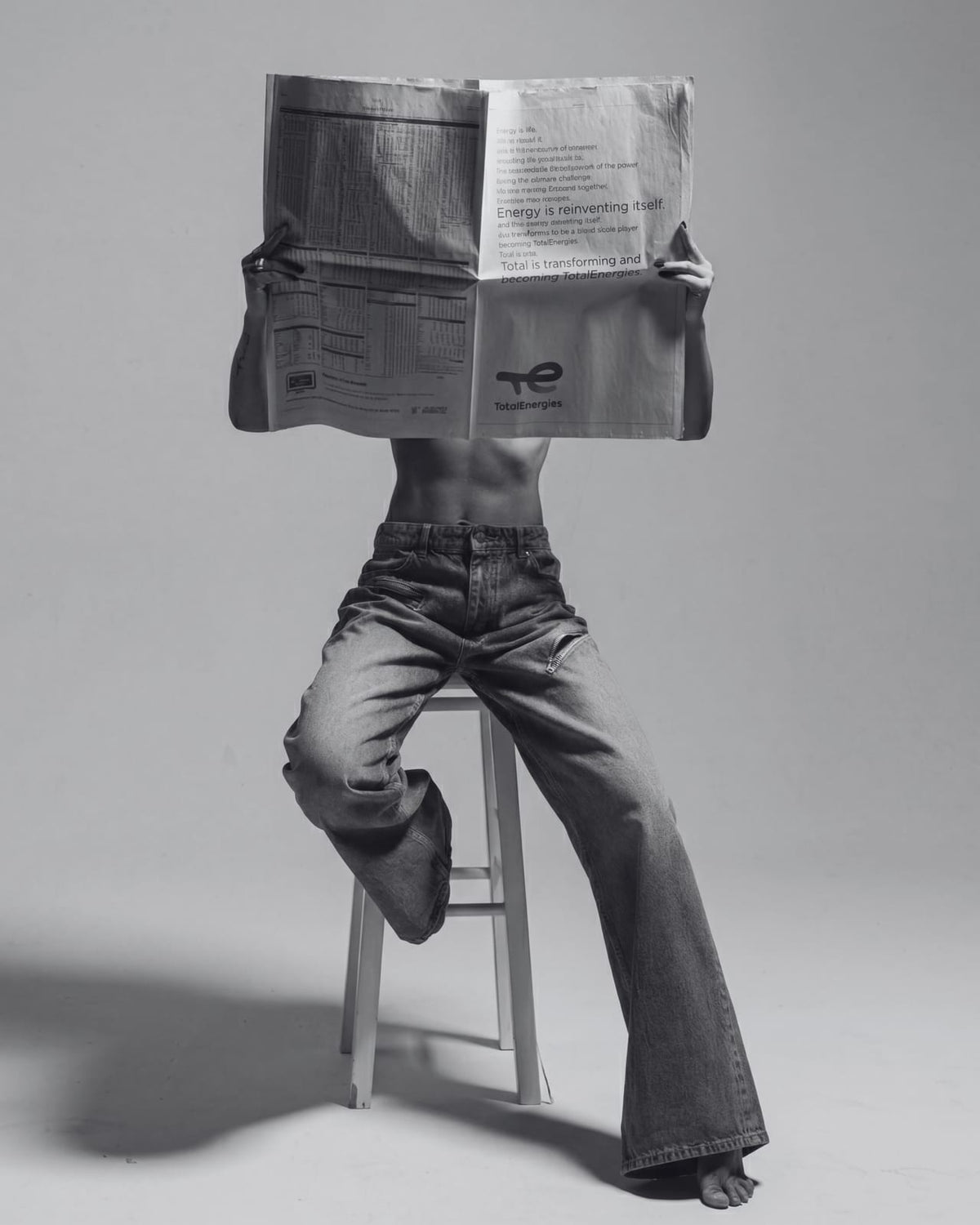 A figure behind an unfolded newspaper.