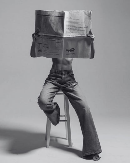 A figure behind an unfolded newspaper.