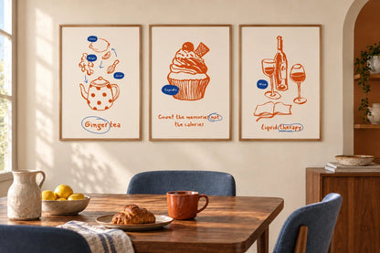 Tea, cupcake, and wine prints hang above a wood dining table in a light room.