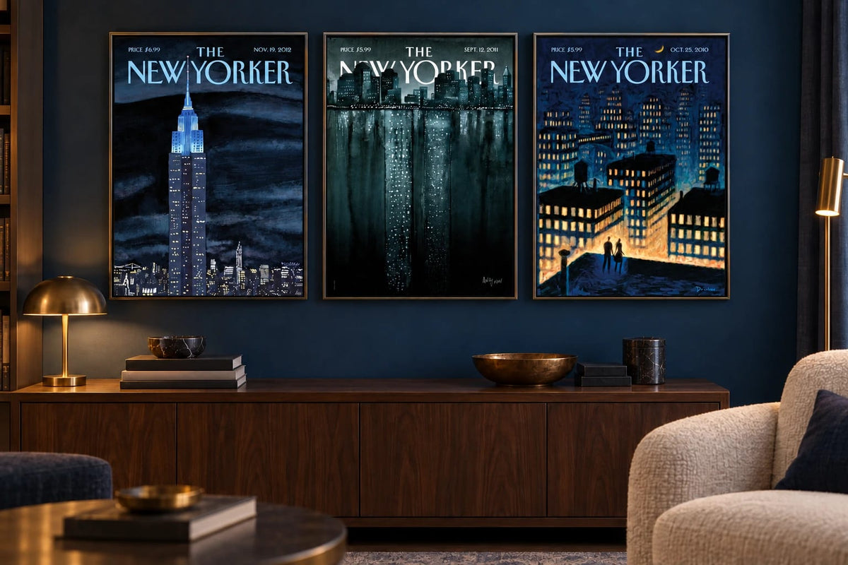 Three night city prints hang on a dark blue wall above a wood cabinet.
