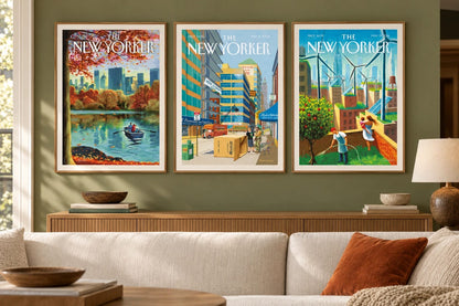 Three urban prints hang on an olive wall above a sofa.