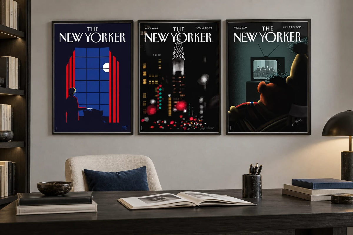 Three dark city prints hang above a desk in a bright office.