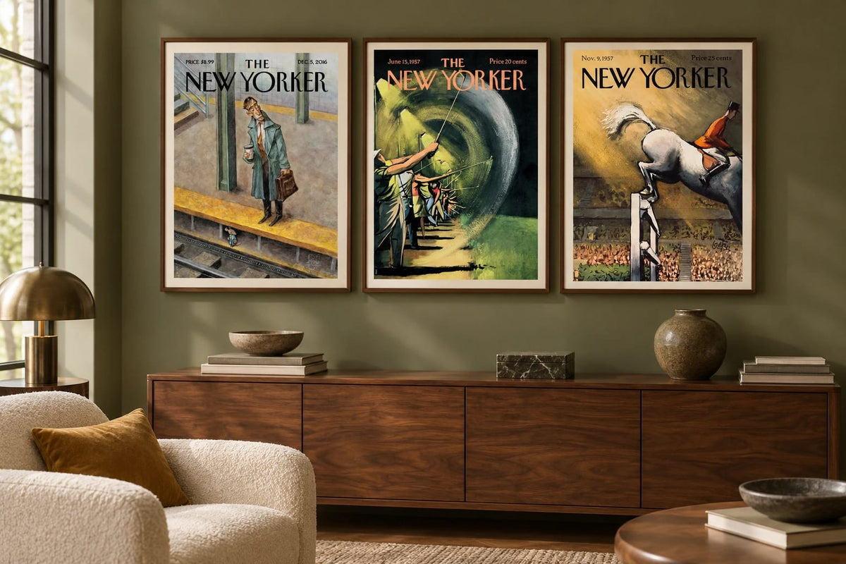 Three vintage prints hang above a walnut cabinet in an olive room.