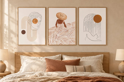 Face, hat, and cat prints above a light bed with neutral bedding.