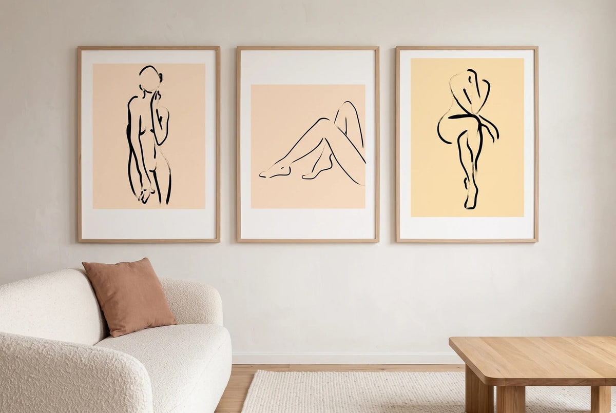 Figure line-art prints displayed in light frames in a bright living room.