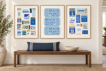 Three blue prints above a bench in a light entryway.