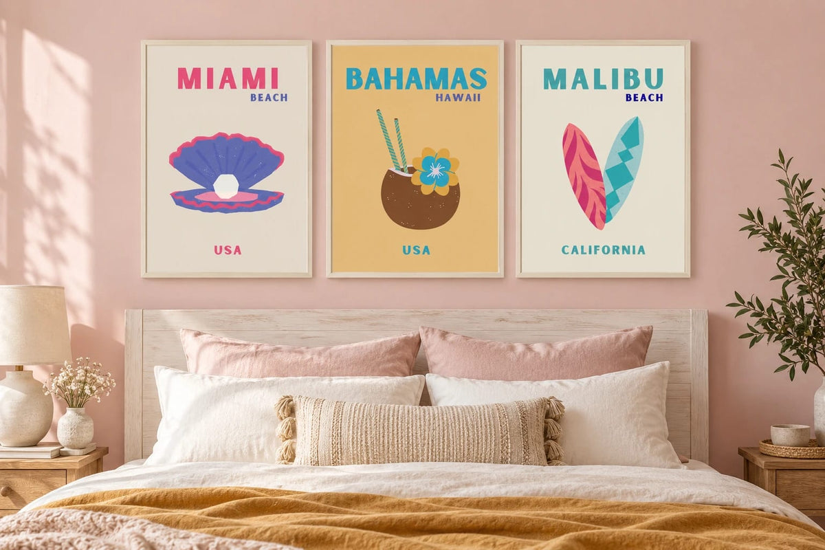 Three bright beach prints above a bed in a pink bedroom.