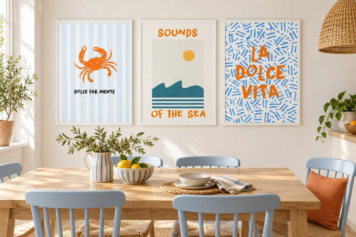 Crab and wave prints above a dining table with blue chairs.