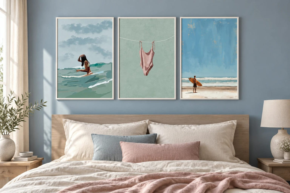 Three swim and surf prints above a bed in a blue bedroom.