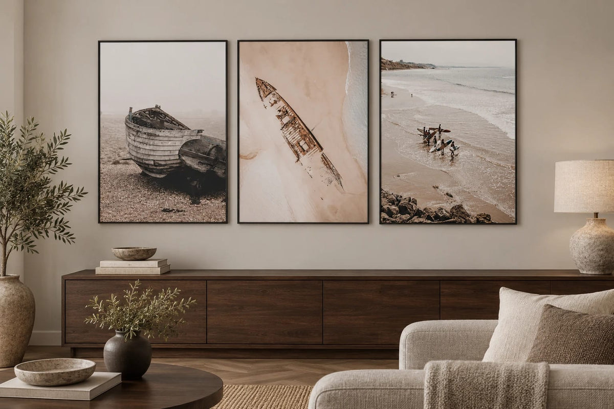 Muted coastal prints above a walnut dresser.
