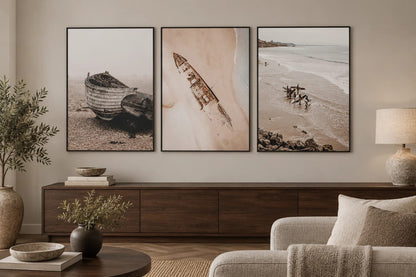 Muted coastal prints above a walnut dresser.