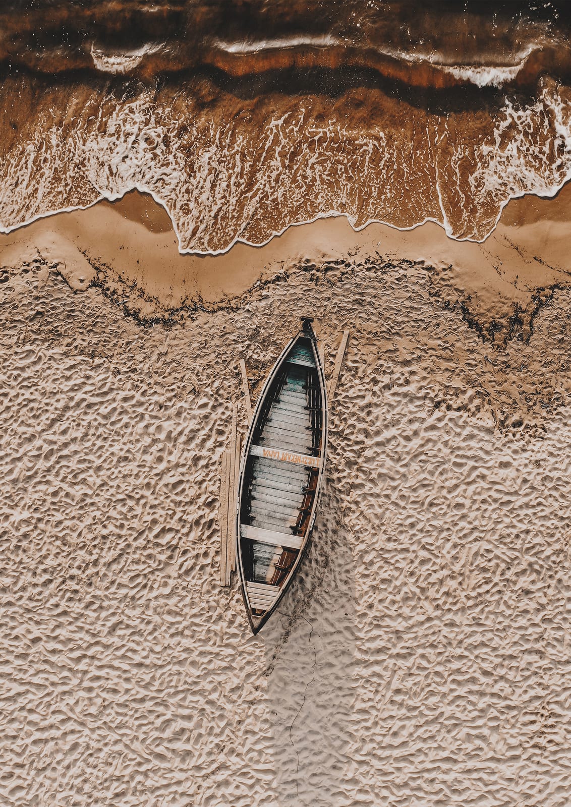 long wooden boat viewed from above beside foam.