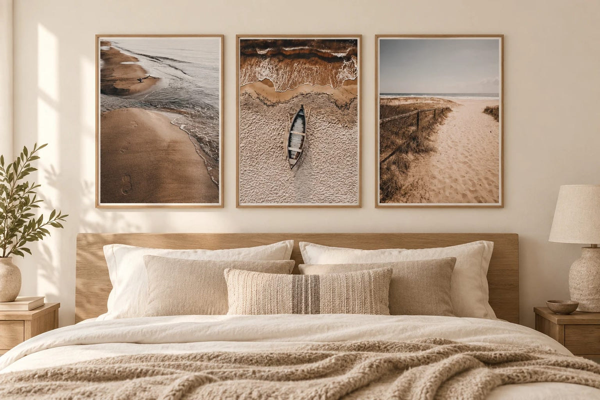 Beach prints above a bed in a beige bedroom.