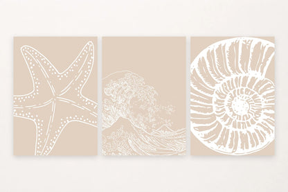 Three beige prints with white sea star, breaking wave, and spiral shell outlines.