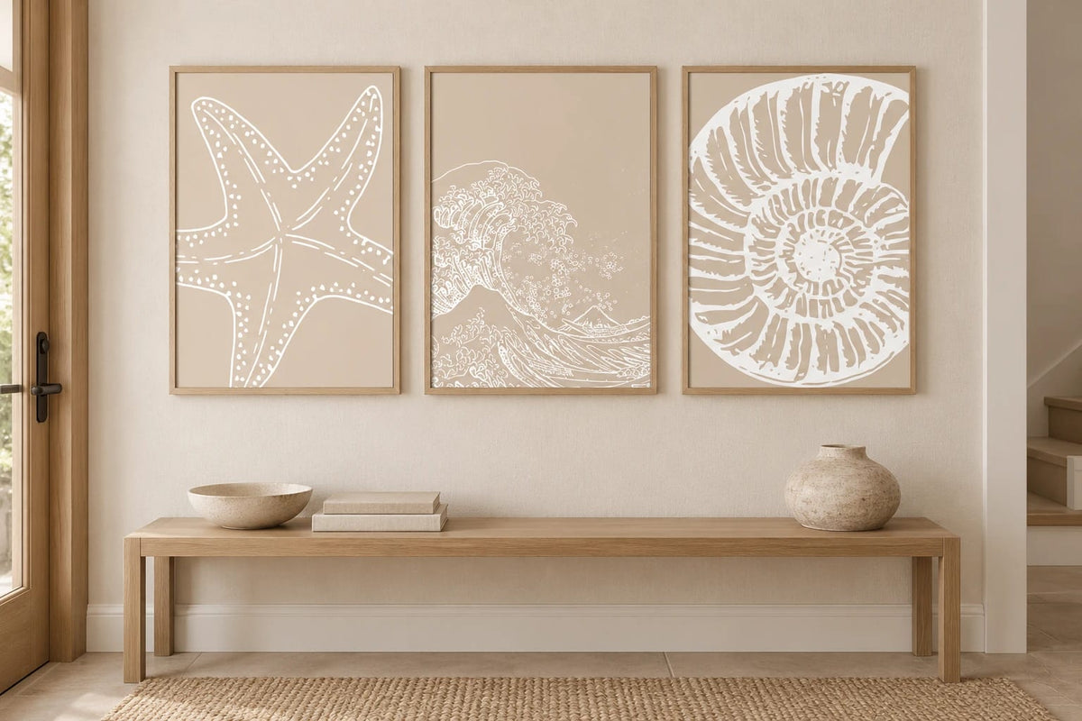 Three neutral marine prints above an oak console.