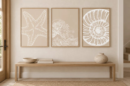 Three neutral marine prints above an oak console.
