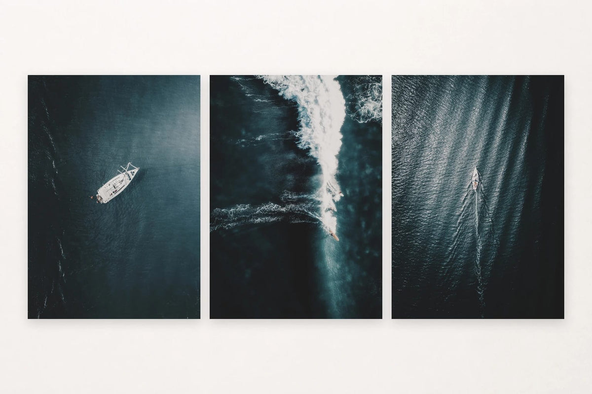 Three dark-water prints with two sailboats and a surfer on a breaking wave.